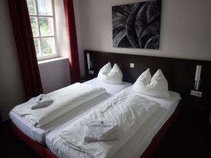 um quarto de hotel com duas camas com lençóis brancos em Altes Pfarrhaus 
