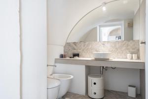 a bathroom with a sink and a toilet and a mirror at Palazzo Rapanà - Luxury Apt with hydromassage pool in Ostuni +17 photos