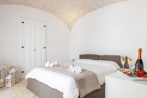 a white bedroom with two beds and a tray of fruit at Palazzo Rapanà - Luxury Apt with hydromassage pool in Ostuni