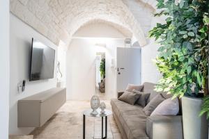 a living room with a couch and a tv at Palazzo Rapanà - Luxury Apt with hydromassage pool in Ostuni