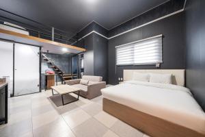 a bedroom with a bed and a living room at Malu Hotel Suwon in Suwon