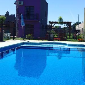 a swimming pool with blue water in front of a house at Un lugar en Monte in San Miguel del Monte