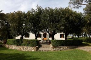 una casa con árboles y arbustos delante de ella en Villa de' Ricci Rignana di Sveva Rocco di Torrepadula en Greve in Chianti