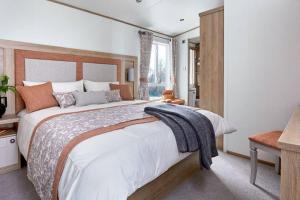 En eller flere senge i et værelse på Captivating Bluebell Lodge 2-bed Cotswolds caravan