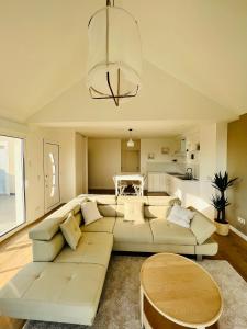 a living room with a white couch and a table at résidence belle vue in Fontaine-le-Port