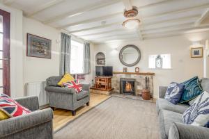 a living room with two chairs and a fireplace at Quirky Cottage in the Heart of St Andrews in St. Andrews