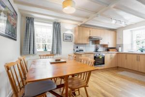 a kitchen and dining room with a wooden table and chairs at Quirky Cottage in the Heart of St Andrews in St. Andrews