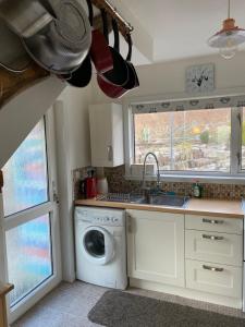 a kitchen with a washing machine and a sink at Cosy 2-Bed House in Kinlochbervie in Kinlochbervie