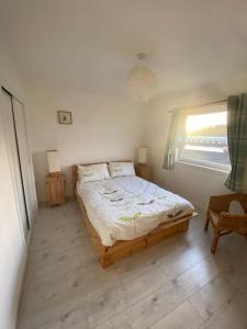 a bedroom with a bed and a window at Cosy 2-Bed House in Kinlochbervie in Kinlochbervie