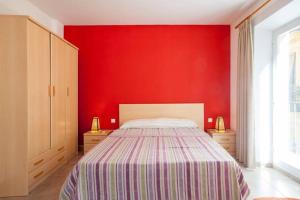 een slaapkamer met een rode muur met een bed erin bij APARTMENT IN OLD CITY / 1TH FLOOR / TERRACE 4 TH FLOOR / PLAZA LA REINA in Valencia