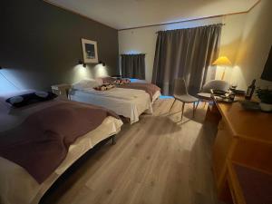 a hotel room with two beds and a desk at Sømna Kro & Gjestegård in Vik +49 photos
