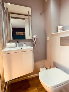 Un baño con inodoro, lavabo y espejo. en Initial by Balladins Lyon Villefranche-sur-Saône, en Villefranche-sur-Saône 73 fotos más