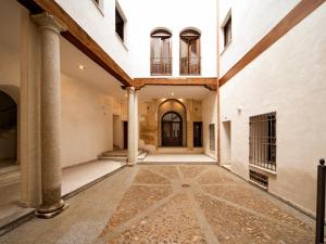un couloir vide d'un bâtiment ancien avec colonnes dans l'établissement Palacio Santa Ursula, à Tolède