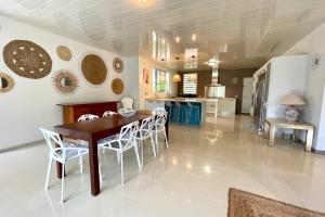 a kitchen and dining room with a table and chairs at Villa Maramatea vast modern and comfy leisure and chill out in Moorea in Vaianae