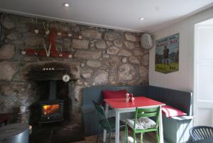 Habitación con mesa y chimenea de piedra. en MHOR 84, en Kingshouse