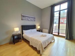 a bedroom with a bed and a large window at Anais Apartments by gaiarooms in Barcelona