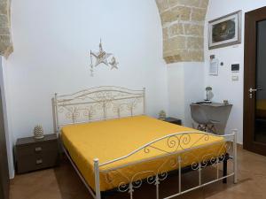 a bedroom with a bed with a yellow blanket at Corte La Rosa in Nardò