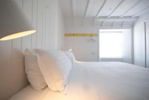 Dormitorio blanco con cama con almohadas blancas en MHOR 84, en Kingshouse