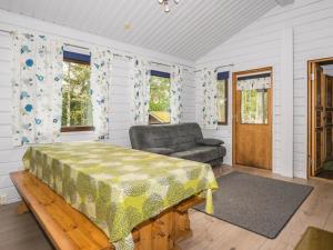 een slaapkamer met een bed, een stoel en ramen bij Holiday Home Aurinkoranta by Interhome in Kolu