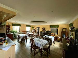 une cuisine et une salle à manger avec des tables et des chaises dans l'établissement Pension Riegler, à Nossen