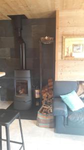 a living room with a stove and a couch at Le Chalet de Lili in Névache