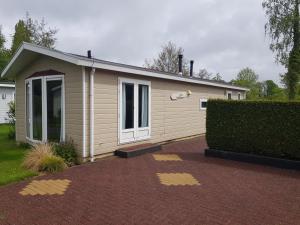 una piccola casa con un vialetto di mattoni davanti di De Bijsselse Enk, Lelie a Nunspeet