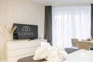 una camera d'albergo con TV e letto di Apartament Baltic Dune z dostępem do basenów,jacuzzi,strefy saun - Pinea Apartments Pobierowo-SANNEL Apartments for rent a Pobierowo