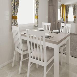 uma mesa de jantar branca com 4 cadeiras brancas em The Salmon Van - Beautiful, luxury static caravan em Aberlour