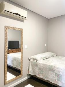 a bedroom with a mirror and a bed at Container na montanha in Siderópolis