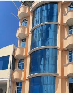 un edificio con ventanas de cristal azul en un lateral en Hostal Carliza, en Puerto Ayora