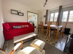 a living room with a red couch and a table at Le gîte de l’espérance in Arc-en-Barrois