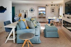 a living room with a blue couch and a table at Lucky Stone Retreat - private beach & Acadia view in Sullivan