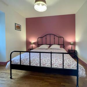 um quarto com uma cama com uma parede roxa em Le gîte de l’espérance em Arc-en-Barrois