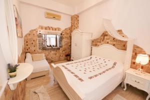 una camera con letto, tavolo e specchio di HERAKLES HOTEL a Çeşme