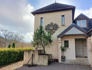 a house with a tree in front of it at 1 Bed Lodge - Sleeps 2 - Parking - Wifi in Acharacle