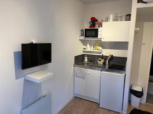 a small kitchen with a sink and a microwave at STUDIO Av MARX DORMOY CLERMONT CENTRE B in Clermont-Ferrand
