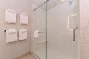 uma casa de banho com uma cabina de duche em vidro e toalhas brancas em Holiday Inn Express & Suites Trinity, an IHG Hotel em Trinity
