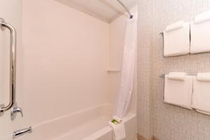 a bathroom with a tub and a toilet and towels at Holiday Inn Express & Suites Trinity, an IHG Hotel in Trinity