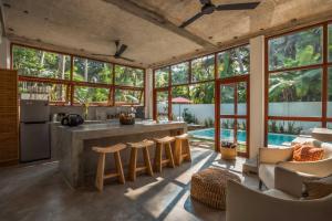 an open kitchen and living room with large windows at Nina Villa in Ahangama