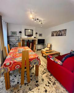 uma sala de estar com uma mesa e um sofá vermelho em Le gîte de l’espérance em Arc-en-Barrois