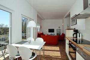 a kitchen and living room with a white table and chairs at Macoma Baltica Wohnung 03 in Kühlungsborn