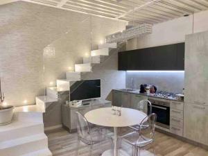 uma cozinha com uma mesa e cadeiras e uma escadaria em Residenza Casanova, appartamento in Giudecca em Veneza