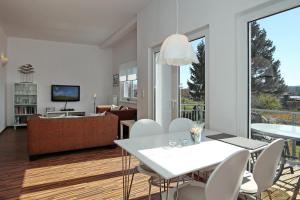 a living room with a white table and chairs at Macoma Baltica Wohnung 04 in Kühlungsborn