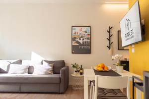 Corso51 Suite Apartments في ريميني: غرفة معيشة مع أريكة وطاولة