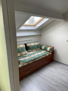een kamer met een bank in een kamer met een raam bij Onder de pannen in Stavoren