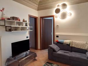 a living room with a couch and a flat screen tv at La Casa dello Spolvero in LʼAquila