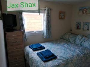 1 dormitorio con 1 cama con 2 toallas azules en The Beach Hut Home from Home in Leysdown on Sea en Sheerness