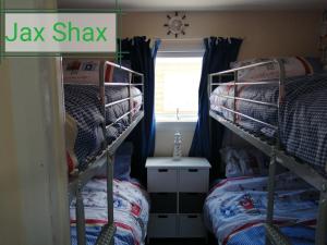1 dormitorio con 2 literas y escritorio en The Beach Hut Home from Home in Leysdown on Sea en Sheerness