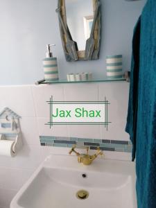 een wastafel in de badkamer met een bord met de naam jakhaai bij The Beach Hut Home from Home in Leysdown on Sea in Sheerness