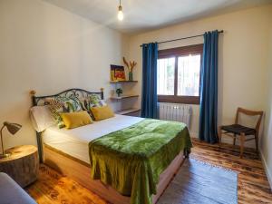 - une chambre avec un lit et une fenêtre avec des rideaux bleus dans l'établissement Villa Can Xum by Hello Homes Sitges, à Canyelles